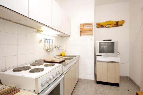 a white kitchen with a stove and a microwave at Apartments by the sea Vis - 8906 in Vis