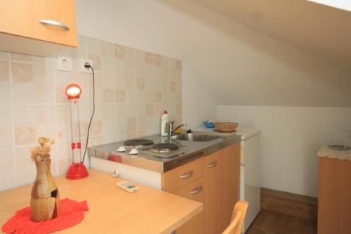 uma cozinha com uma mesa, um lavatório e um balcão em Apartments with WiFi Komiza, Vis - 8911 em Komiža