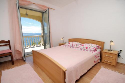 a bedroom with a bed and a large window at Apartments by the sea Brna - Vinacac, Korcula - 9152 in Smokvica