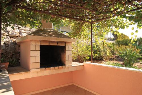 a patio with an outdoor fireplace in a yard at Apartments by the sea Zavalatica, Korcula - 9137 in Zavalatica