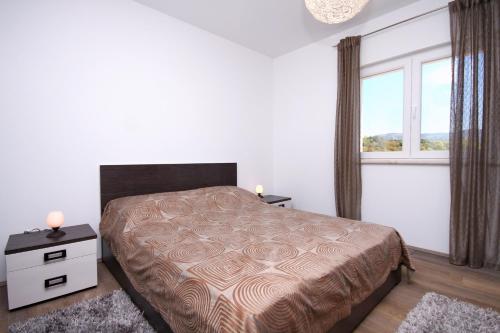 a bedroom with a bed and a window at Apartments by the sea Zavalatica, Korcula - 9138 in Zavalatica