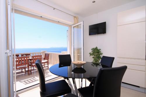 a dining room with a table and chairs and a balcony at Apartments by the sea Zavalatica, Korcula - 9138 in Zavalatica