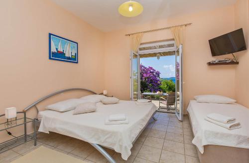 een slaapkamer met 2 bedden, een tv en een raam bij Apartments with a parking space Mlini, Dubrovnik - 9043 in Mlini