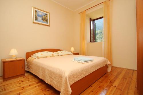 a bedroom with a bed and a window at Holiday house with a swimming pool Dubravka, Dubrovnik - 9101 in Gruda