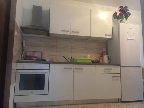 cocina con armarios blancos y nevera blanca en Apartments by the sea Cove Mala Pogorila, Hvar - 8953, en Bogomolje