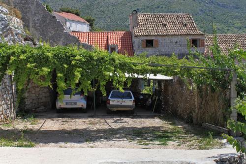 a group of cars parked in a yard with vines at Double Room Zaton Mali 8997a in Zaton