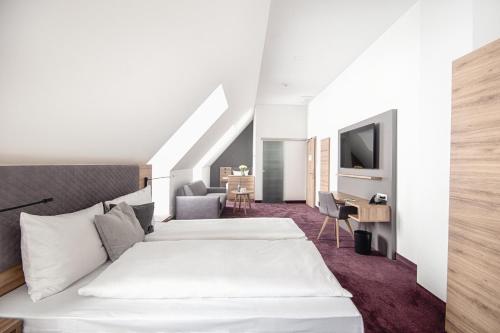 ein Hotelzimmer mit 2 Betten und einem Schreibtisch in der Unterkunft Hotel Kupferzell in Kupferzell