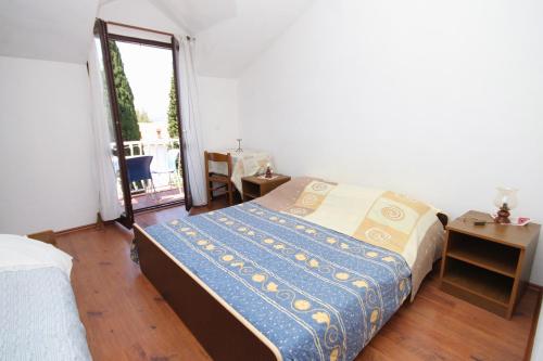 a bedroom with a bed and a window and a table at Apartments with a parking space Cavtat, Dubrovnik - 8993 in Mlini