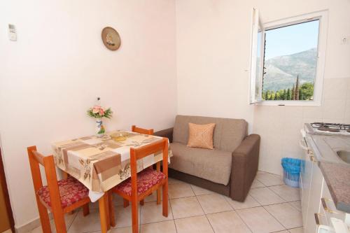 a living room with a table and a couch at Apartments with a parking space Cavtat, Dubrovnik - 8993 in Mlini