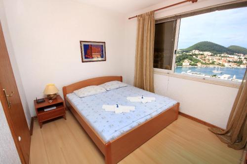 a bedroom with a bed and a large window at Apartments with WiFi Dubrovnik - 8975 in Dubrovnik