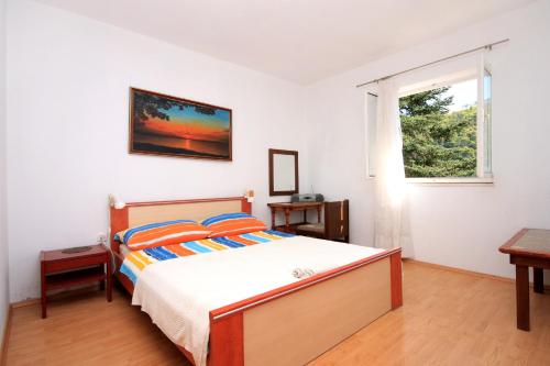 a bedroom with a bed and a window at Apartments by the sea Brna, Korcula - 9139 in Brna