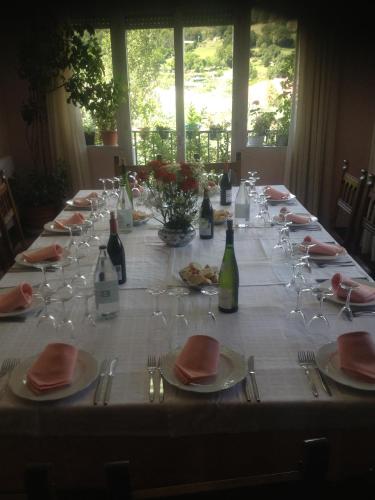a long table with wine bottles and glasses on it at Hotel Can Mestre in El Pont de Suert