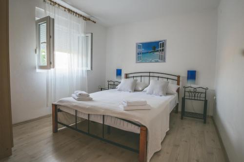 una camera da letto con un grande letto con lenzuola bianche di Apartments with a parking space Rukavac, Vis - 8898 a Vis