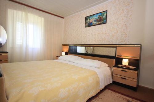 um quarto de hotel com uma cama grande e uma janela em Apartments with WiFi Trsteno, Dubrovnik - 9015 em Trsteno