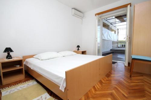 a bedroom with a large bed and a sliding glass door at Apartments and rooms by the sea Molunat, Dubrovnik - 8964 in Gruda
