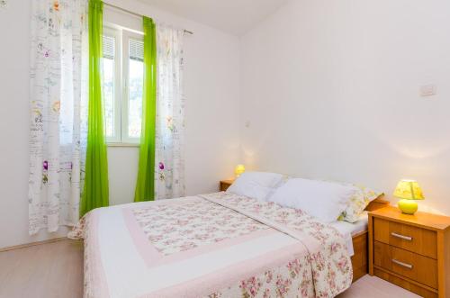- une chambre avec un lit doté de rideaux verts et d'une fenêtre dans l'établissement Apartments by the sea Sladjenovici, Dubrovnik - 9012, à Slano