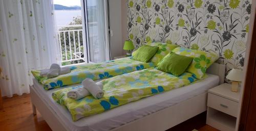 a bed with stuffed animals on it in a room with a window at Apartments with a parking space Vrbica, Dubrovnik - 9008 in Dubrovnik