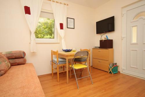sala de estar con mesa, sillas y TV en Apartments for families with children Mlini, Dubrovnik - 8970 en Mlini
