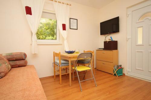 ムリニにあるApartments for families with children Mlini, Dubrovnik - 8970のテーブルと椅子とテレビのあるリビングルーム