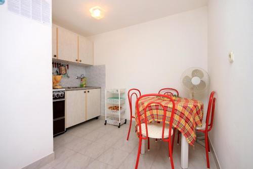 een keuken met een tafel en stoelen in een kamer bij Apartment Prigradica 9141b in Blato