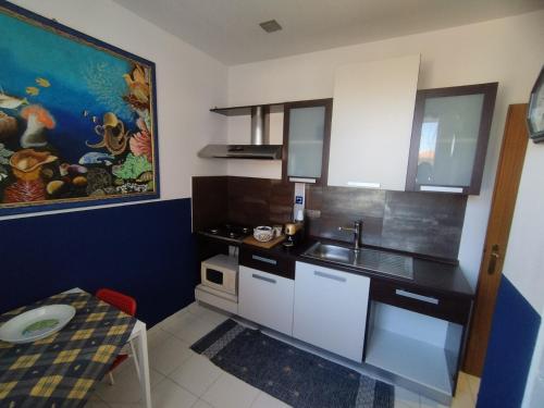 a small kitchen with a sink and a table at Greenhouse in Mascalucia