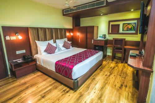 a hotel room with a bed and a desk at Hotel Cama in Chandīgarh