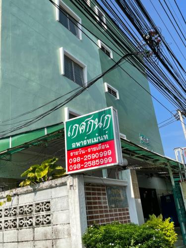 a sign on the side of a building at Gedkanok Apartment in Bangkok
