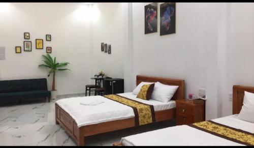ein Schlafzimmer mit zwei Betten und einem Sofa darin in der Unterkunft Khách sạn KEN HOTEL DĨ AN in Dĩ An