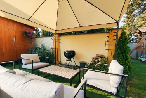 a gazebo with chairs and a grill in a yard at Apartmány na kolonádě in Lednice