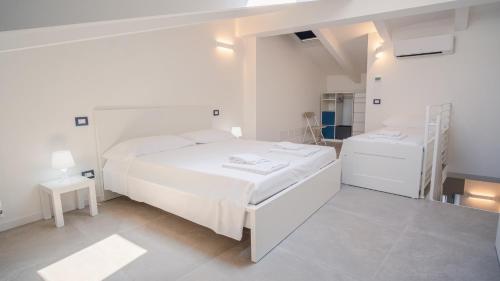 a white bedroom with a white bed and a staircase at Elide Home Sweet Home - Italian Homing in Padenghe sul Garda