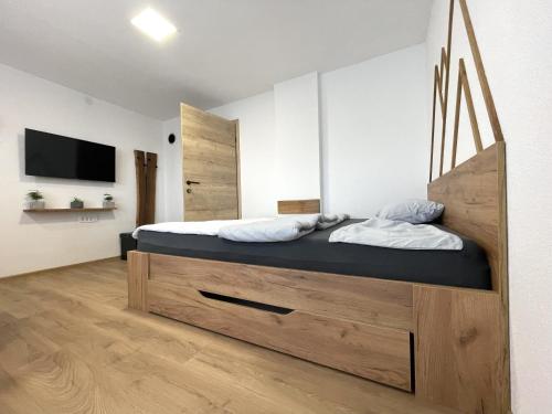 a bedroom with a large bed with a wooden headboard at Apartments and rooms pri Bašlju in Cerkno