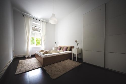 sala de estar blanca con sofá y ventana en Zagreb Central Park Apartment with free parking, en Zagreb