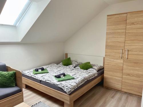 a bedroom with a bed with green pillows at Ubytování nad sklípkem v Šatově in Šatov