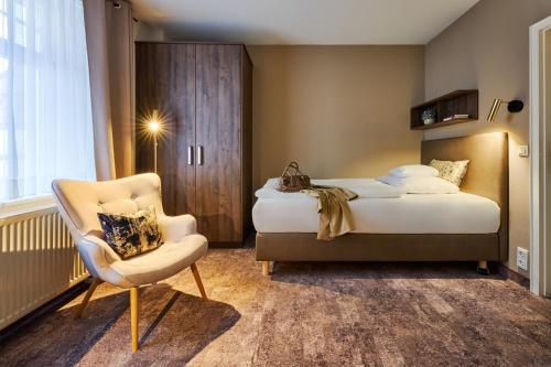 a hotel room with a bed and a chair at Romantik Hotel am Brühl in Quedlinburg