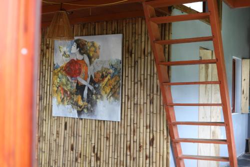 a painting of a woman on a wall next to a ladder at Mộc Châu Peachy Garden in An Pon