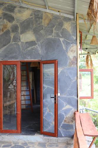 a stone building with a door and a bench at Mộc Châu Peachy Garden in An Pon