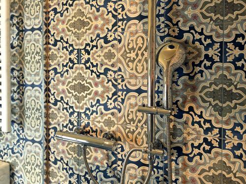a bathroom with a shower with blue and gold wallpaper at Hof Wetzenow Self Check In in Rossow