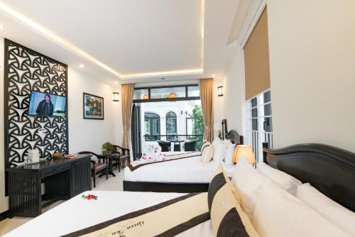 1 dormitorio con 2 camas y ventana grande en Green Tea Villa, en Hoi An