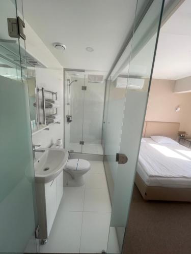 a bathroom with a sink and a toilet and a bed at Boutique Hotel Dacha Lanzheron in Odesa