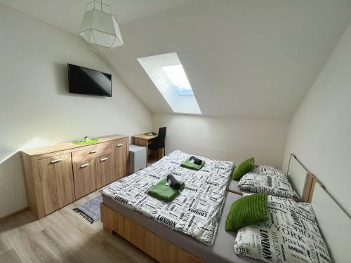 a attic bedroom with two beds and a tv at Ubytování nad sklípkem v Šatově in Šatov