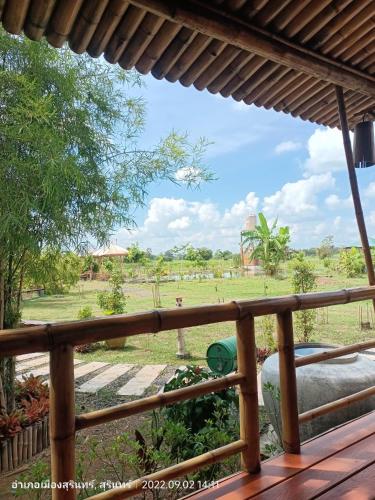 a view of a field from the deck of a house at สวนเกษตรรักษ์ไผ่ Bamboo Conservation Farm in Surin