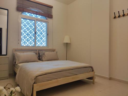 a bedroom with a large bed and a window at Cozy 1BR Apartment close to Dragon Market and Global Village in Dubai