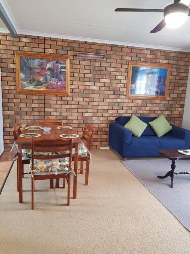 a living room with a blue couch and a table at Sally's Retreat in Kingscote