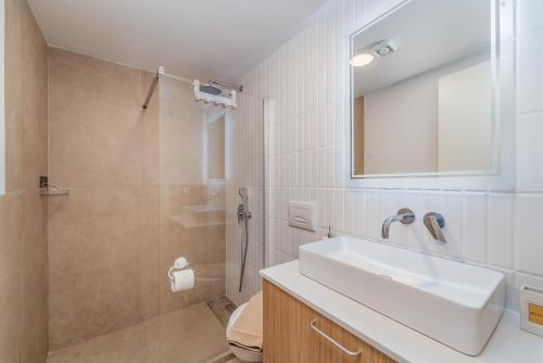 uma casa de banho com um lavatório e um chuveiro em Greek Beach House B2 Lefkada em Nydri