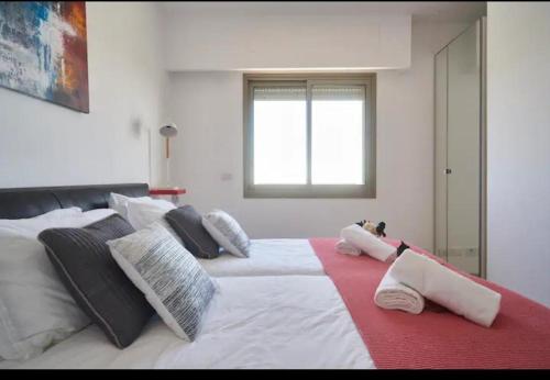 uma grande cama branca com almofadas e uma janela em Unique View - 2 BR & 2 BTH - Monbaz streetM em Jerusalém