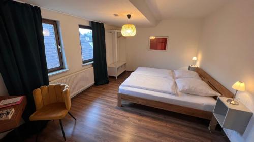 a bedroom with a bed and a desk and a chair at Hotel Sonne in Wassertrüdingen