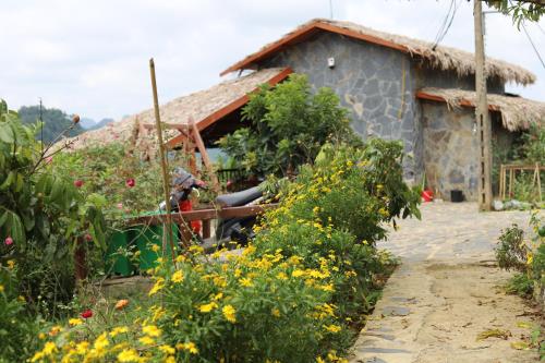 a garden in front of a house with flowers at Mộc Châu Peachy Garden in An Pon