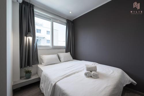 um quarto com uma cama branca com duas toalhas em Bourn, Nilie Hospitality MGMT em Tessalônica