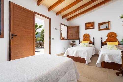 a bedroom with two beds and a door at Can Sion in Esporles