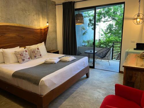 a bedroom with a bed and a sliding glass door at Little Gem Hotel Tulum La Veleta in Tulum